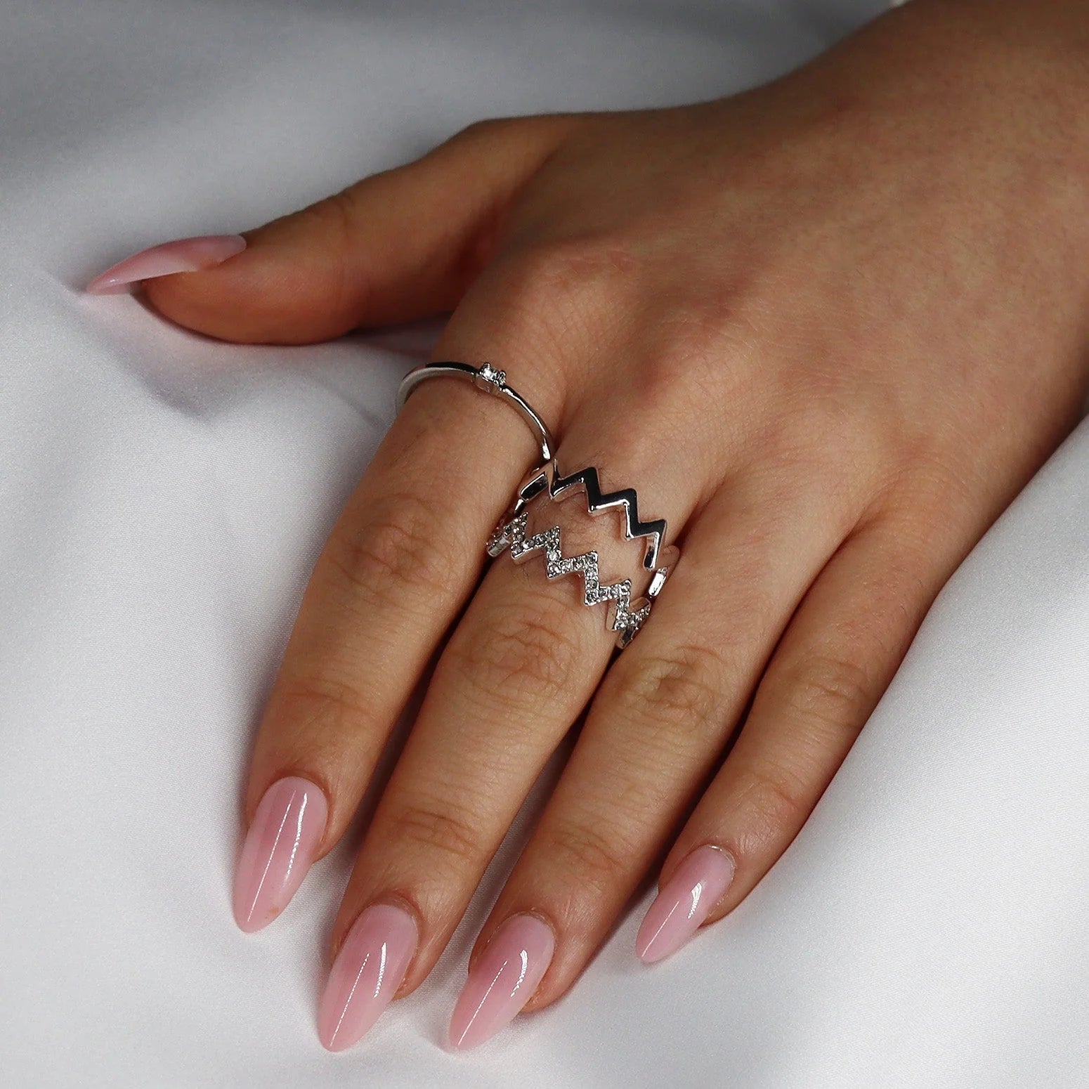 Pinkie Pearl gelénaglar styling – rosa pearl manikyr med silverring mot vit satin