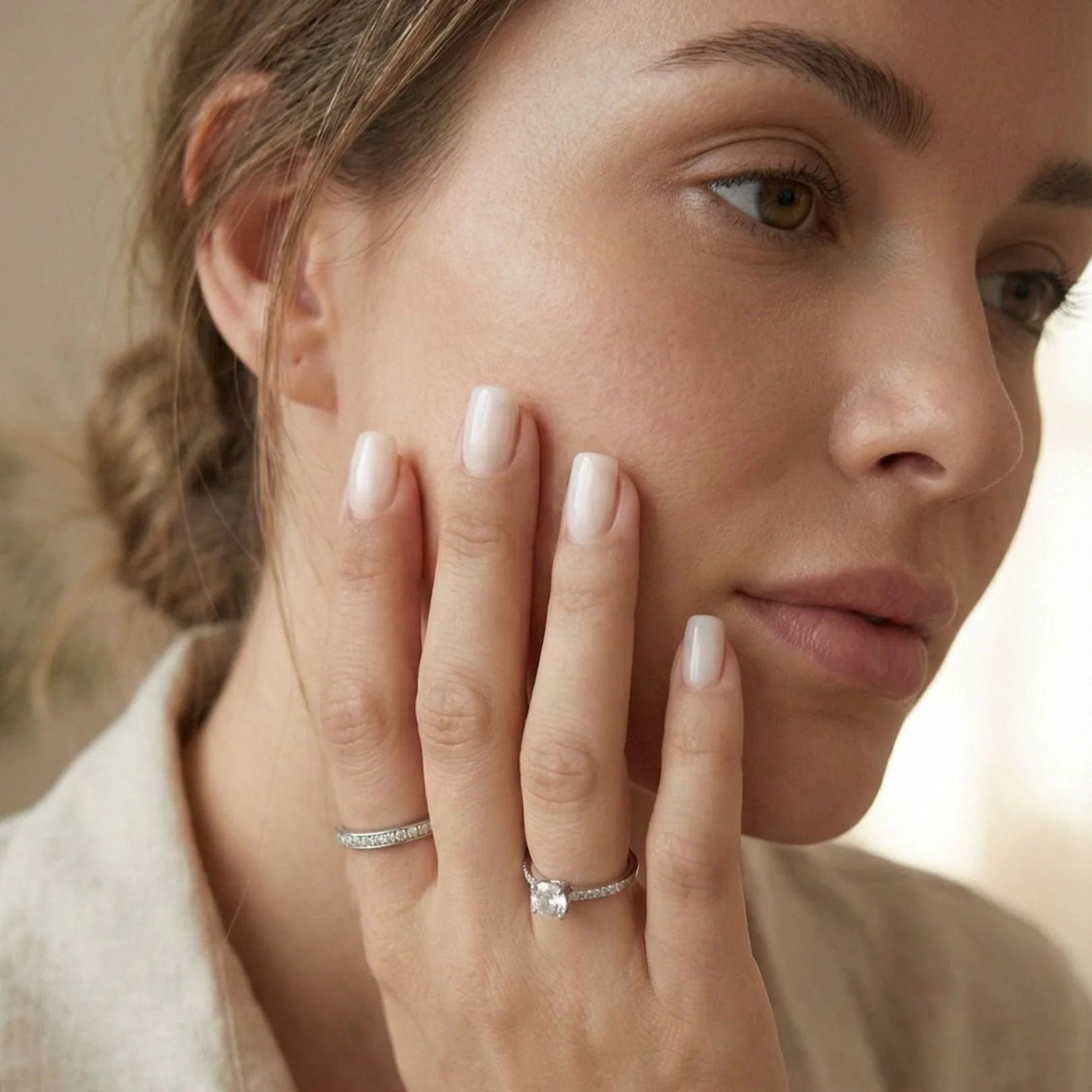 Pure Pearl press-on naglar styling – kort square nude pearl mot ansiktet med silverring