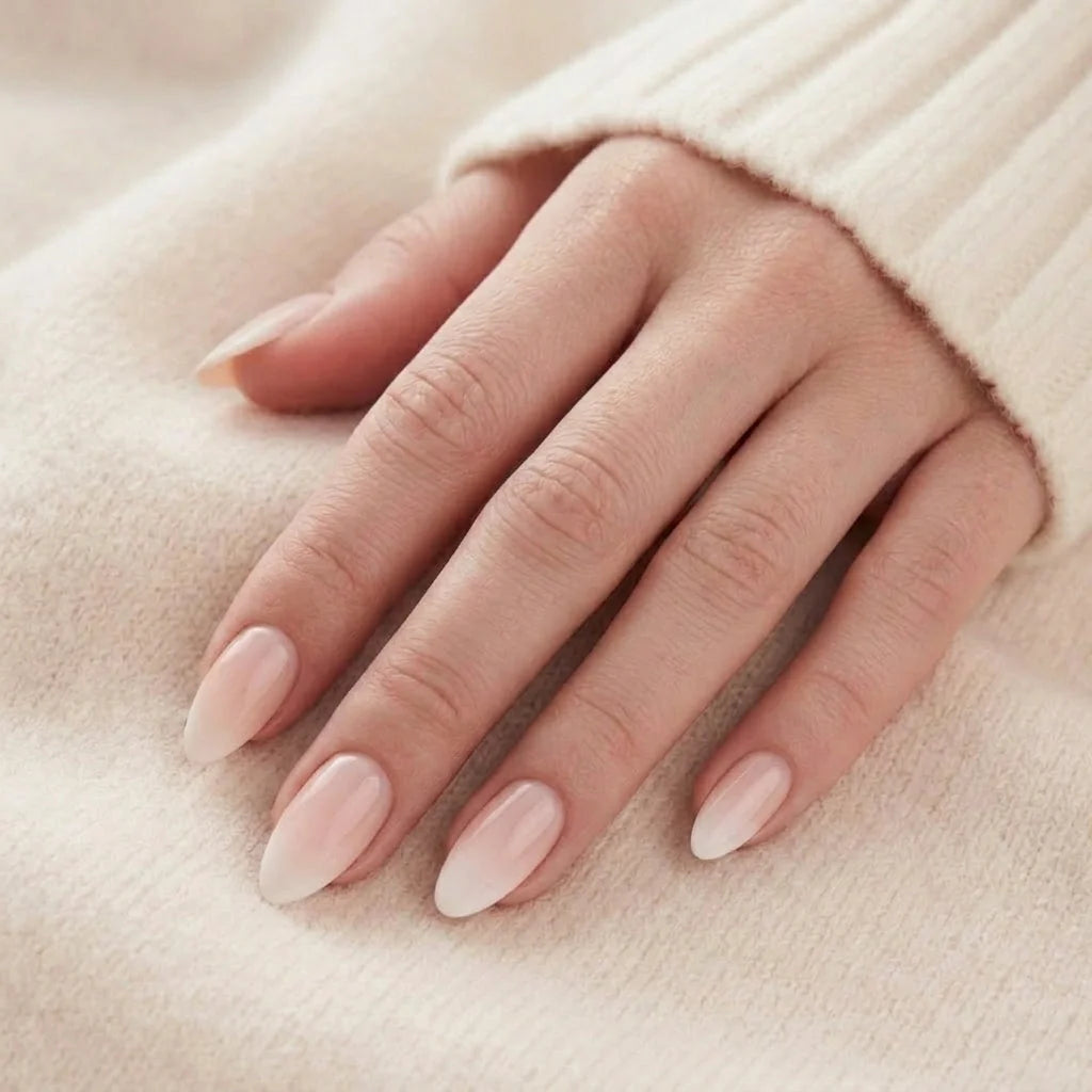 Dreamy Dip naglar på hand – nude rosa ombre mandelnaglar mot beige stickad tröja