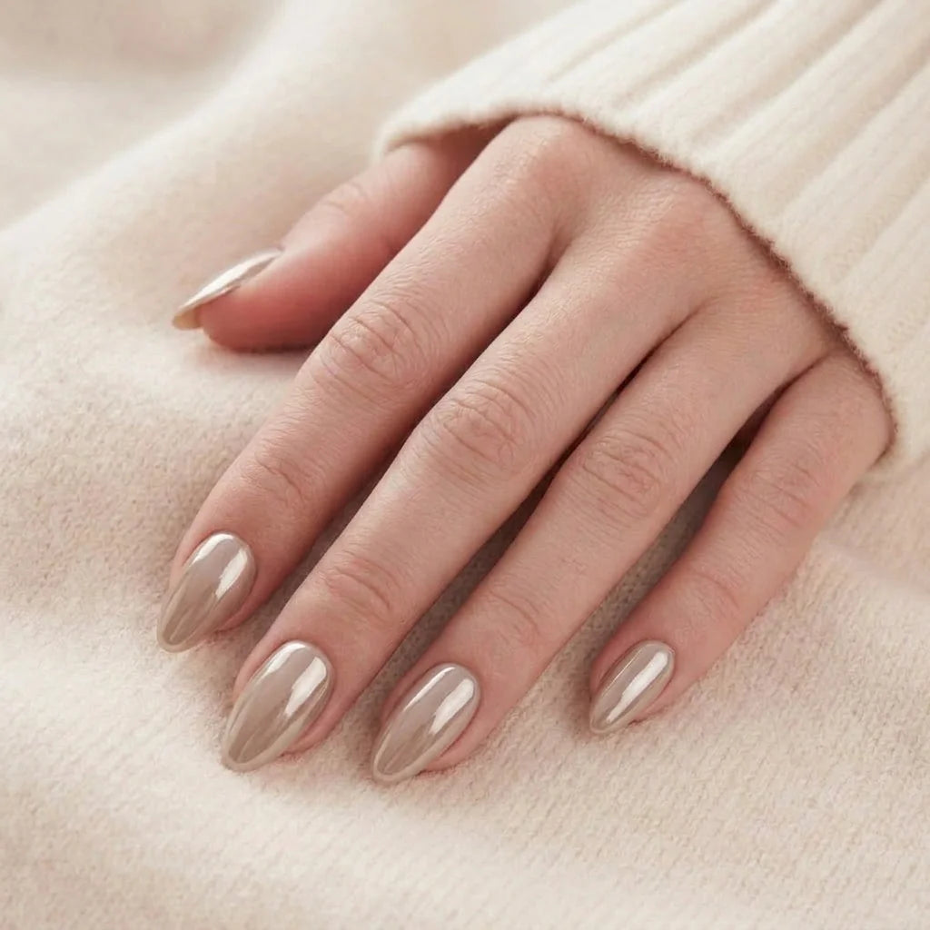 Pearly Perfection naglar på hand – mandelformade gelénaglar i pärlemor taupe vilar mot beige tröja