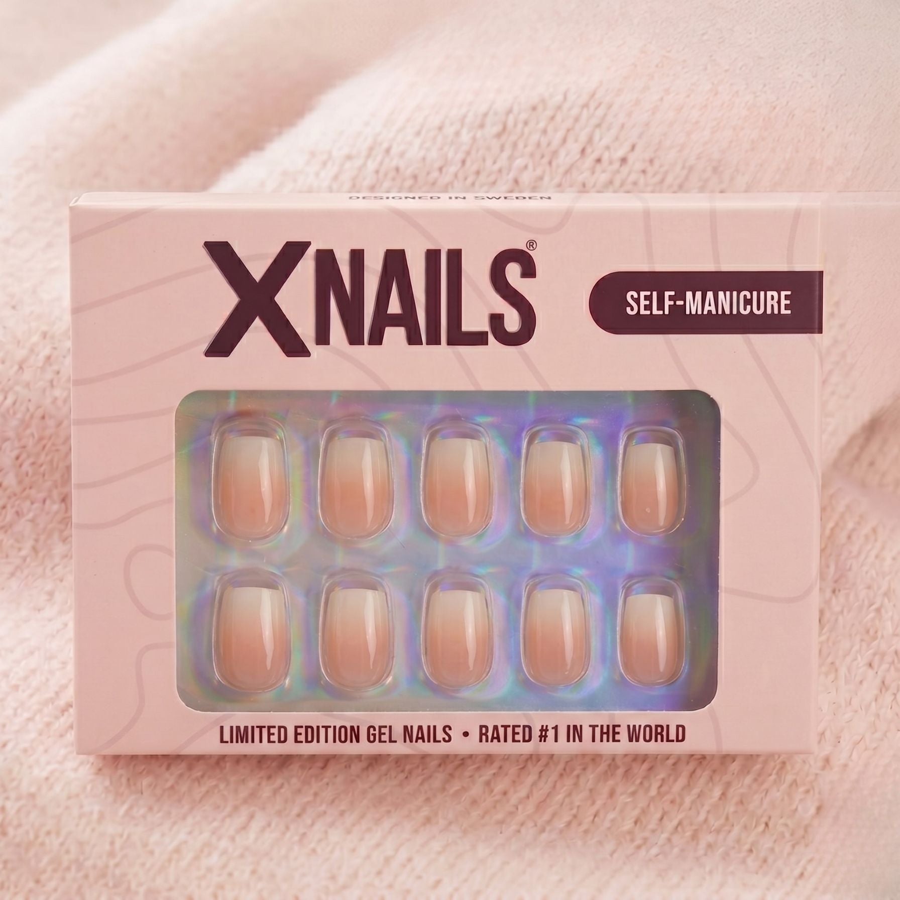 Dreamy Dip XNails förpackning – limited edition gelénaglar i square med rosa-vit ombré mot beige stickad bakgrund