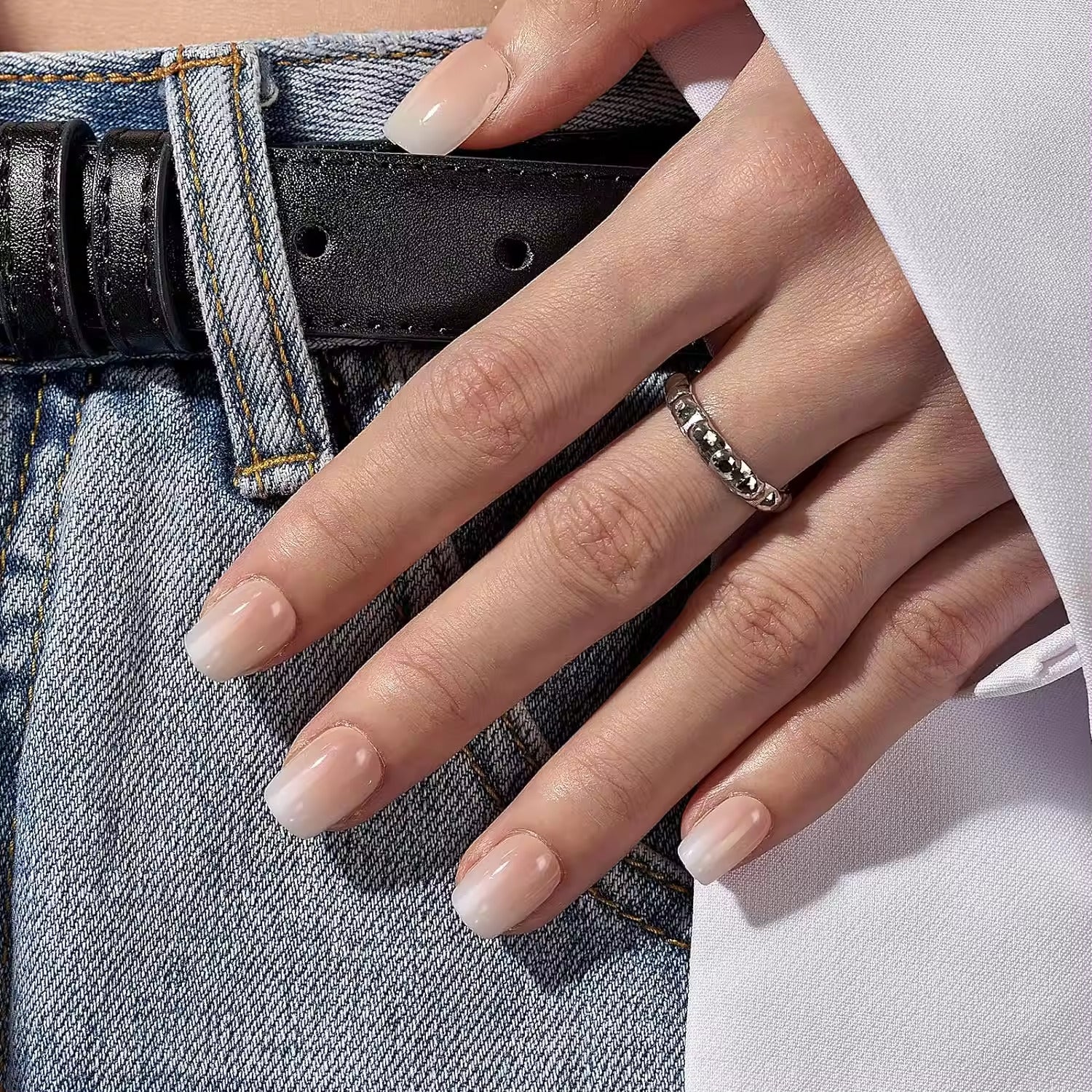 Nude ombre lösnaglar – kort almondform mot ljusa jeans och silverring XNails