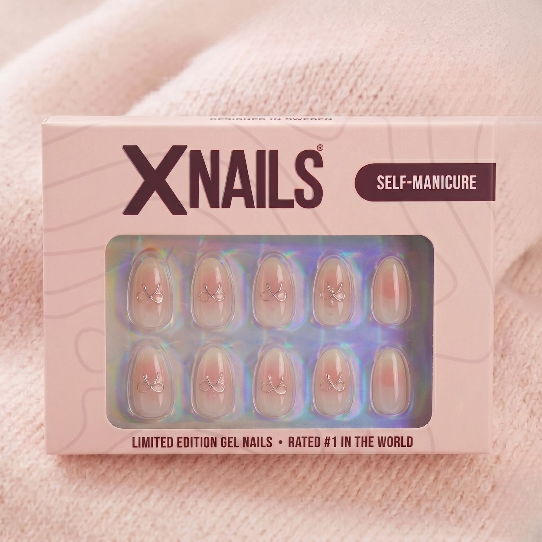 Aura Amoré mandelformade press-on naglar med vit/rosa ombré och silveröglor, i rosa XNails förpackning för enkel manikyr