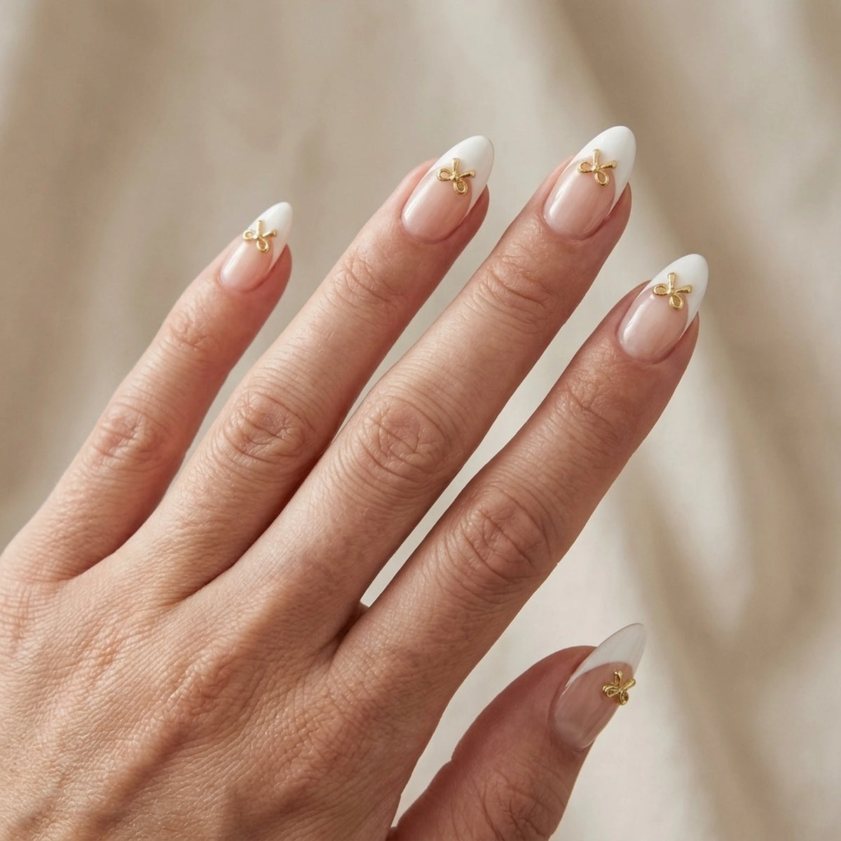 Ongles press-on Blushing Bow en amande avec french blanche et nœud 3D