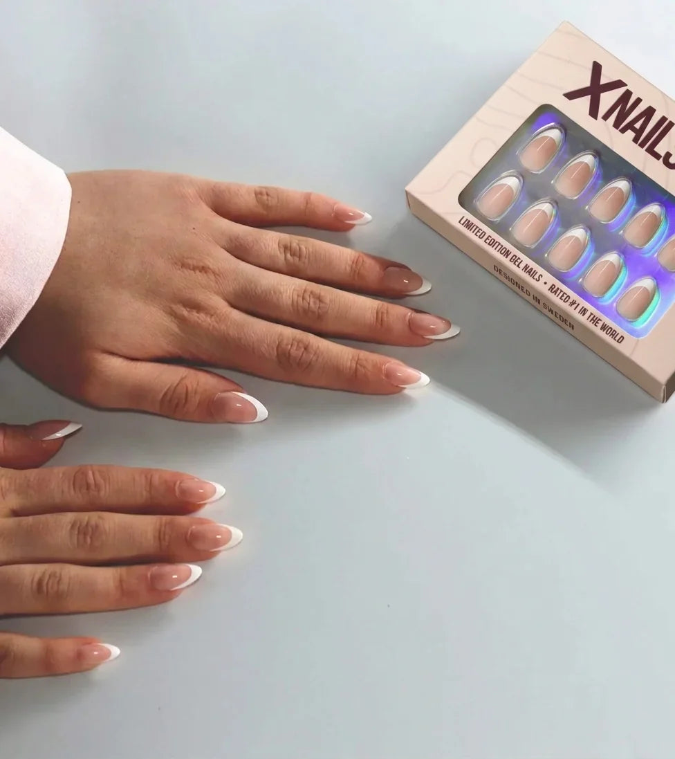 Två händer med franska press-on-naglar bredvid den beige XNails-asken