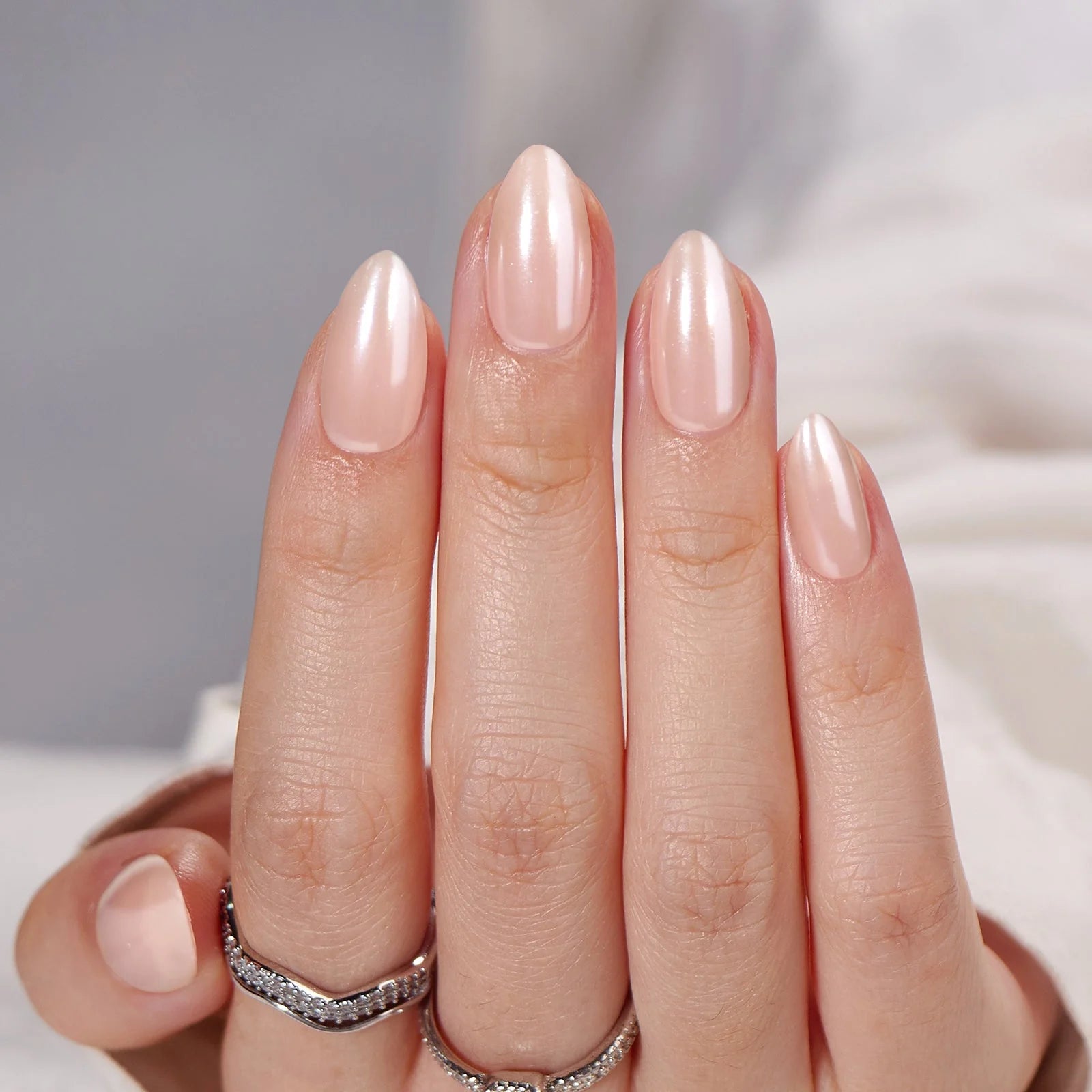 Heavenly Halo gelénaglar närbild – pearl shimmer i mandelform mot vit satin