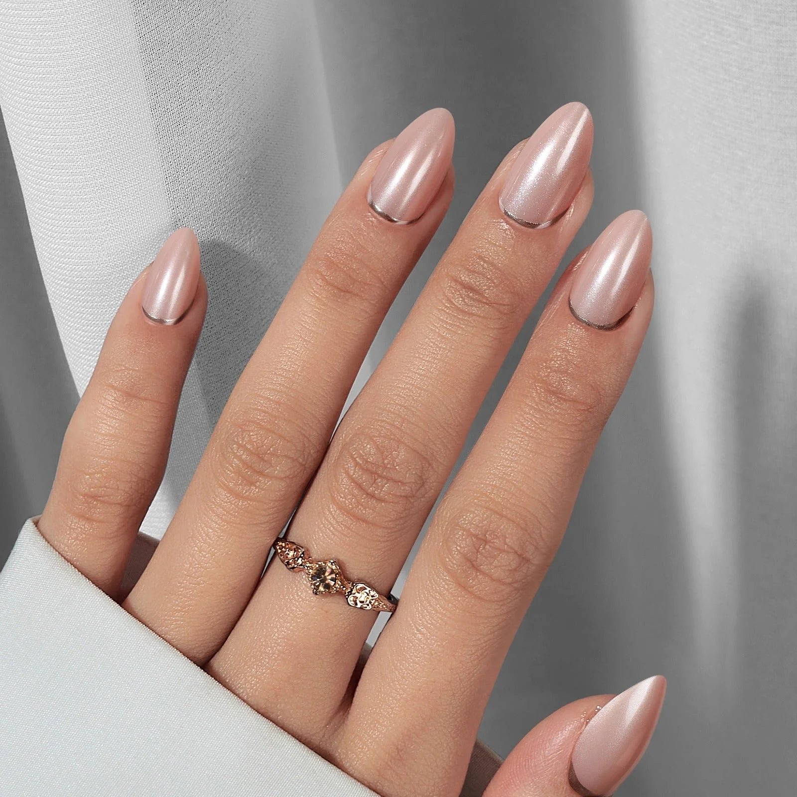 Mandelformade lösnaglar med pärlglans – Shimmering Silver med rosé-ring mot grå sidengardin