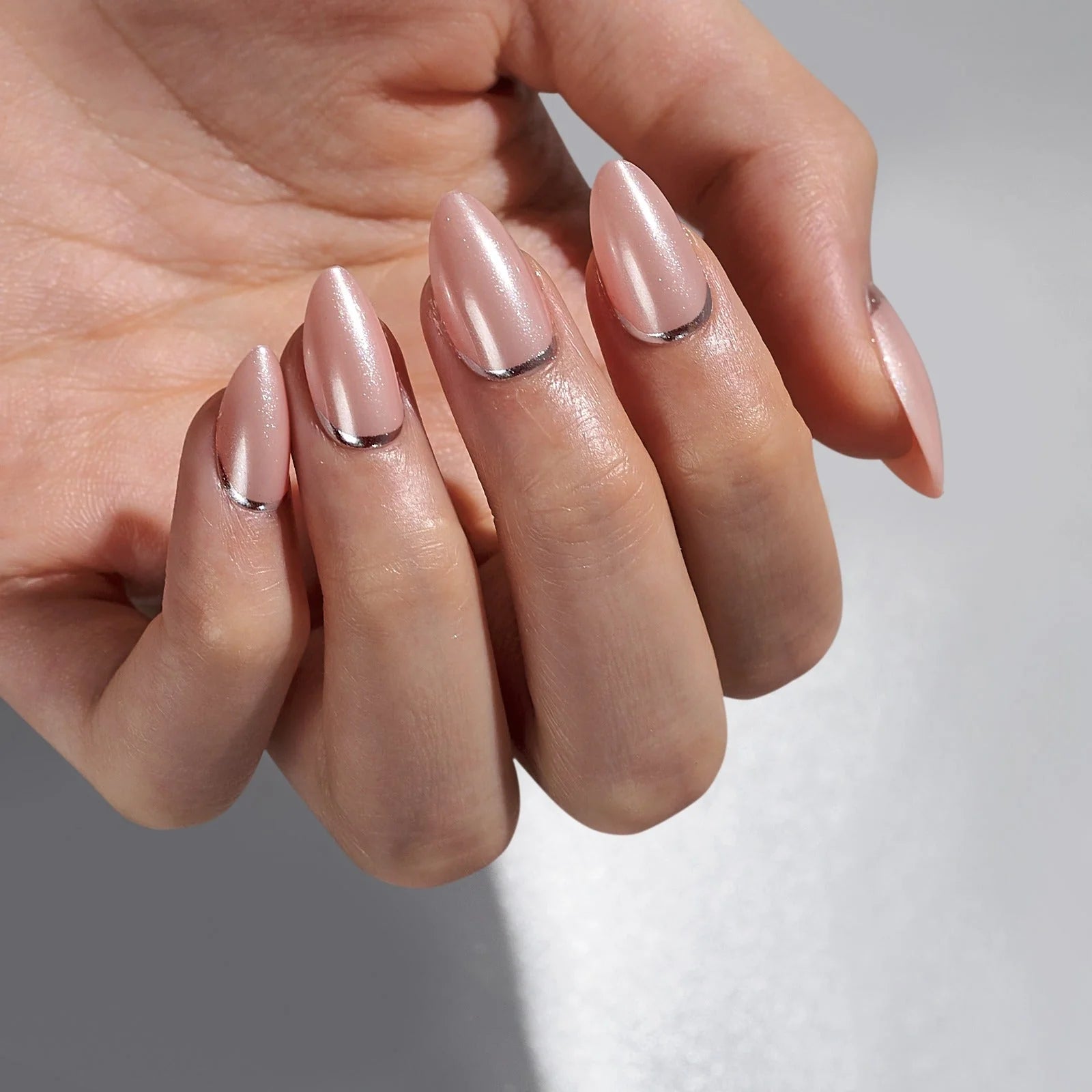 Shimmering Silver gelénaglar närbild – pearl nude mandelform med chrome silverkant