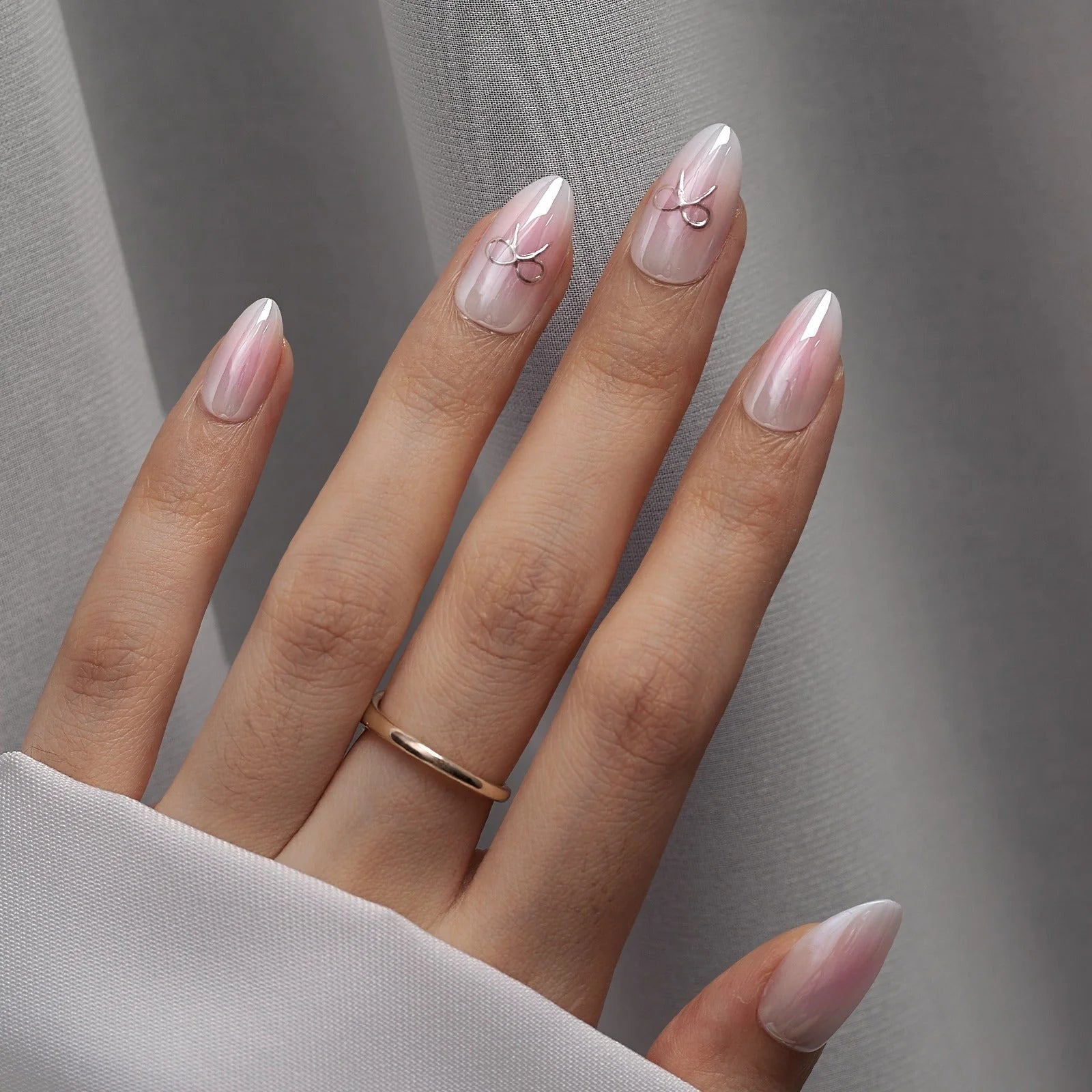 Aura Amoré press-on naglar närbild – rosa white pearl aura i mandelform mot grå satin