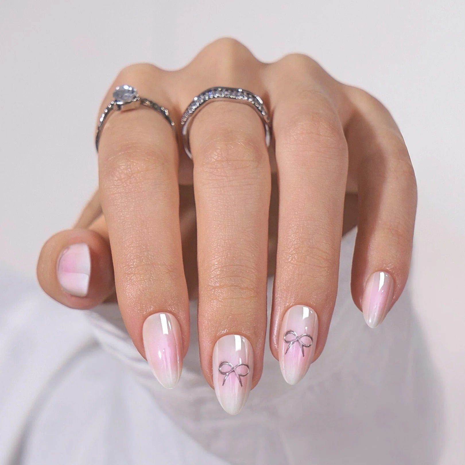 Aura Amoré naglar på hand – pink white aura med silverrosett detalj och silverringar