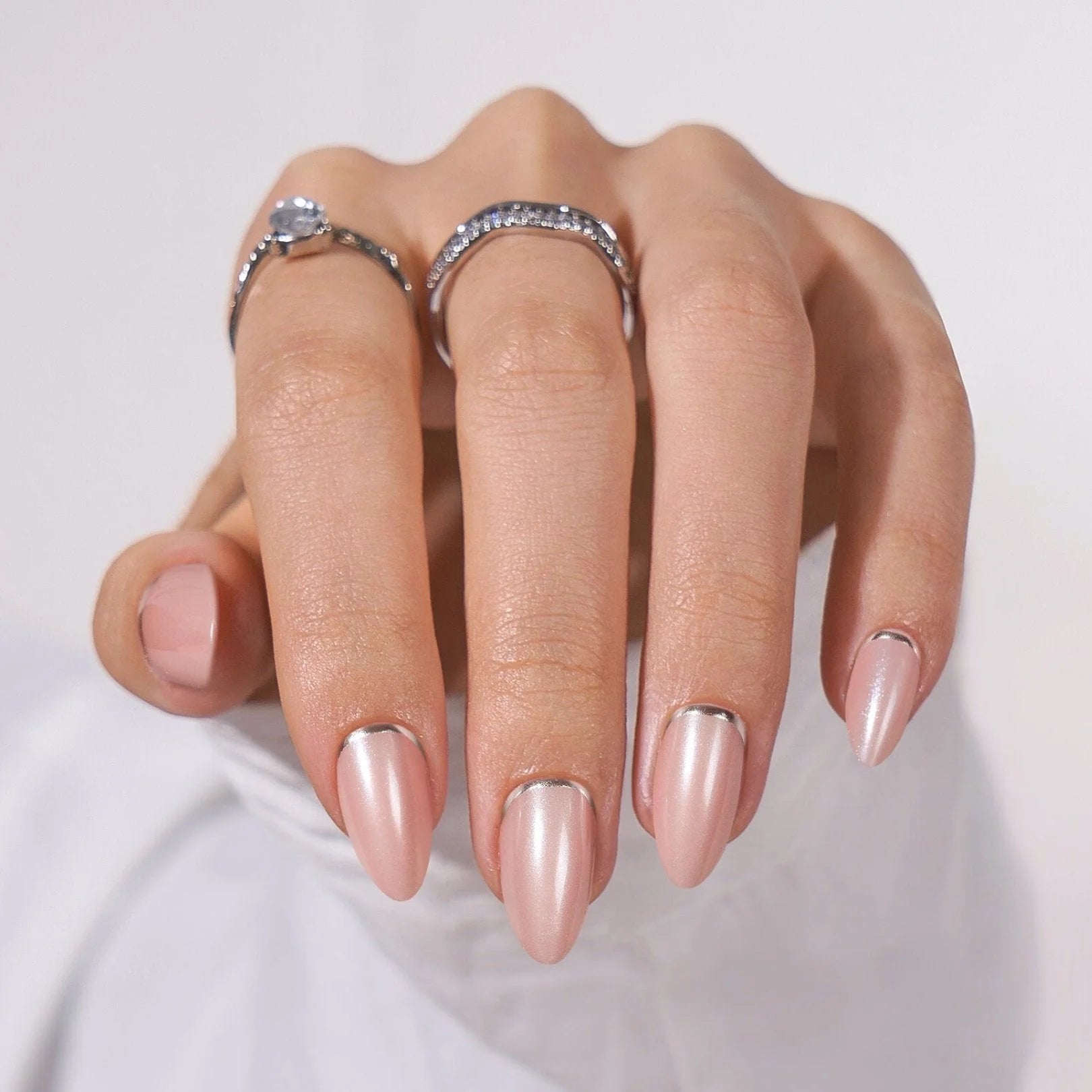 Shimmering Silver press-on naglar närbild – mandelform med silverkant och kristallringar mot vit duk