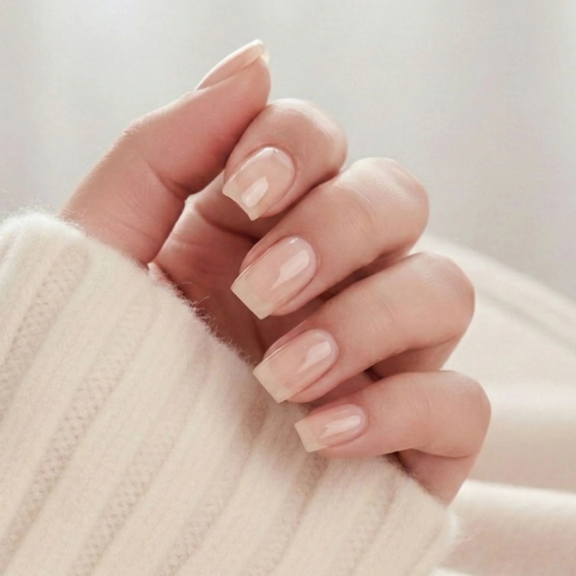 Heavenly Halo press-on naglar – korta square lösnaglar i mjuk nude med subtilt skimmer mot beige tröja