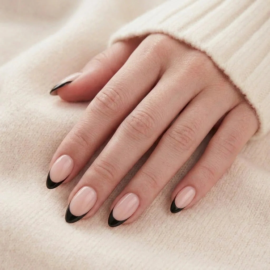 Sleek Silhouette lösnaglar närbild – nude mandelformade gelénaglar med svart french-tipp på beige bakgrund