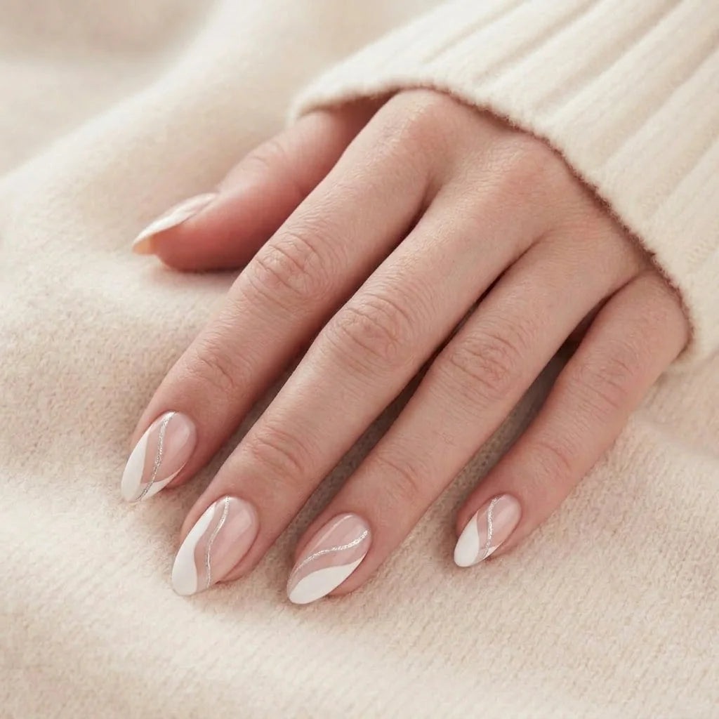 Metallic Merge lösnaglar närbild – mandelformade gelénaglar med silver swirl mot mjuk beige stickad bakgrund
