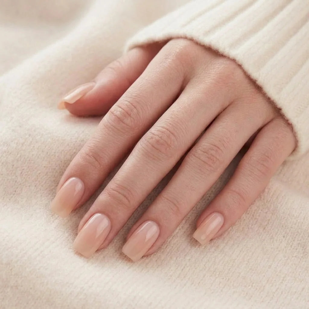 Heavenly Halo lösnaglar närbild – korta square gelénaglar i nude med pearl-glans mot beige stickad bakgrund