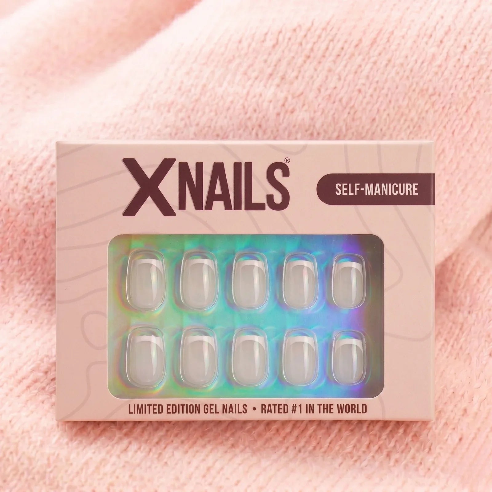 XNails-förpackning french frost short square press-on naglar mot rosa stickad bakgrund