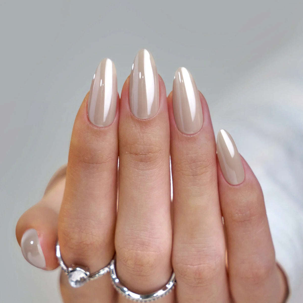 Faux ongles forme amande à éclat nacré, Pearly Perfection en taupe nude avec bagues argentées
