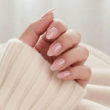 Faux ongles Pinkie Pearl, rose nacré délicat en forme amande sur un pull tricoté crème