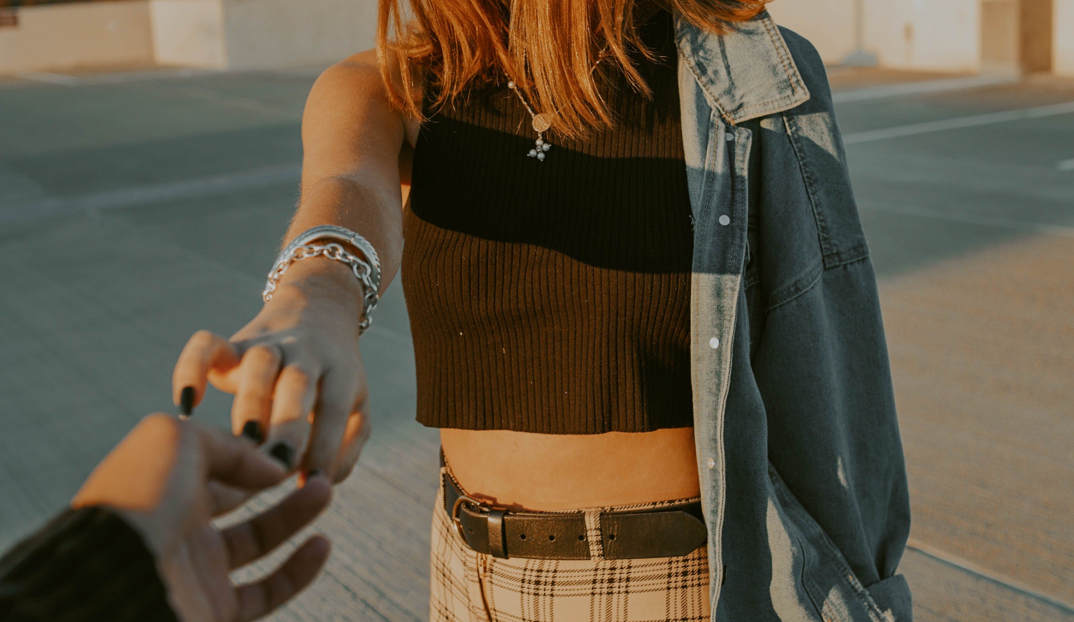Lifestyle modell i jeansjacka och rutig kjol visar press-on naglar utomhus – XNails kampanj