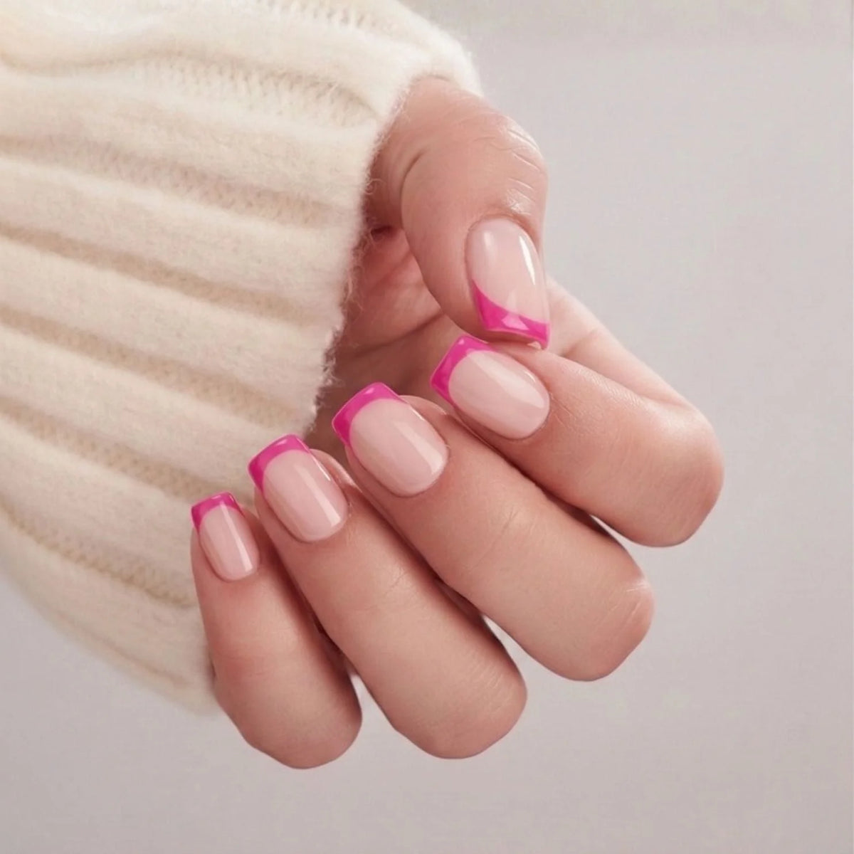 Ongles gel Pixie Pink en gros plan, pointe française rose sur base nude en forme carrée courte